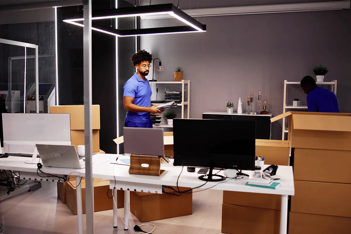 Equipo de mudanzas embalando mobiliario de oficina para traslado corporativo